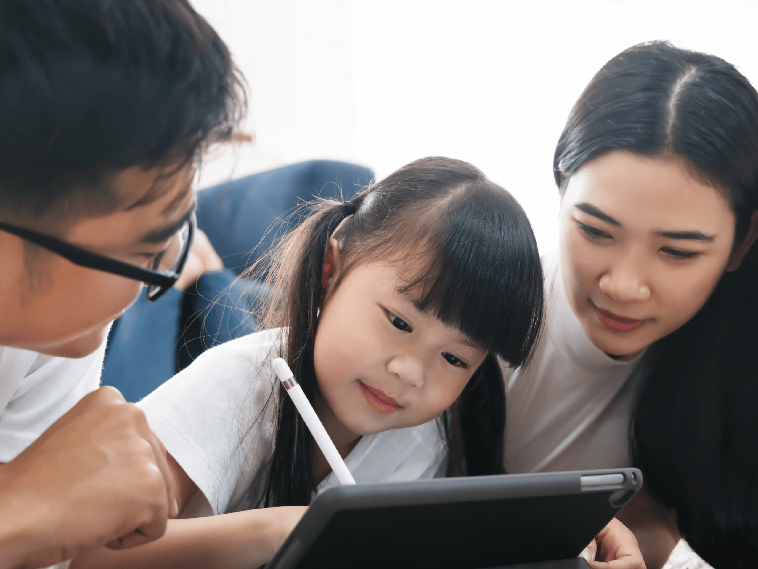 Bé gái học cách quản lý tiền thông qua ứng dụng trên máy tính bảng cùng bố mẹ